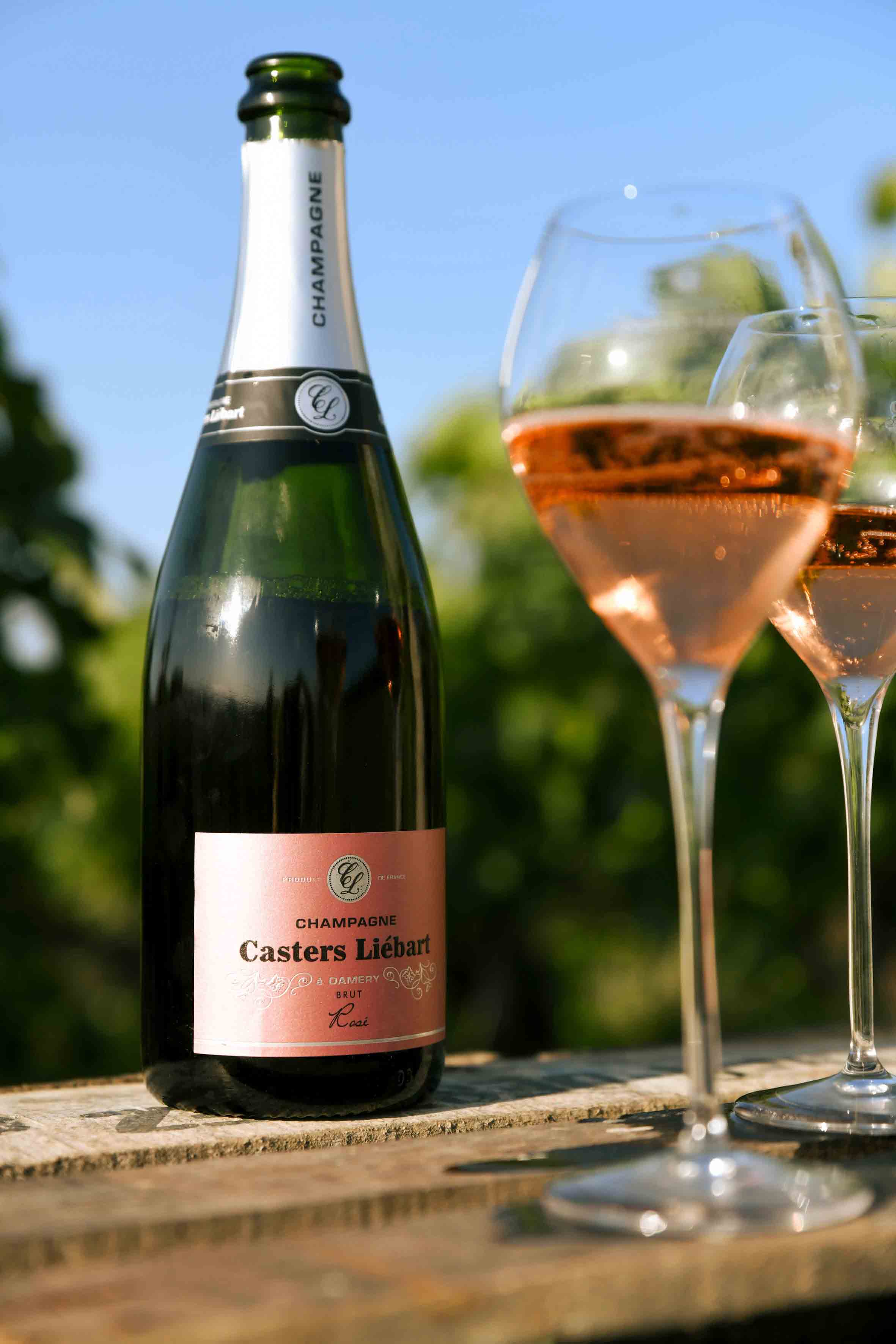 Champagnerflasche mit Cgampagnergläser auf einer Holzkiste in den Weinreben